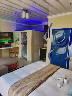 a bedroom with a large bed with a blue ceiling at Blackwood Guest House in Pretoria