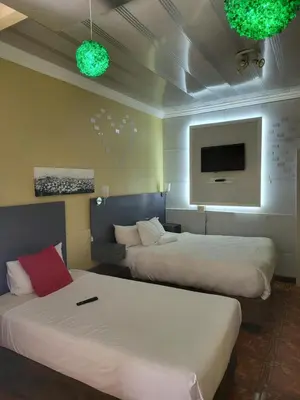 a hotel room with two beds and a flat screen tv at Blackwood Guest House in Pretoria