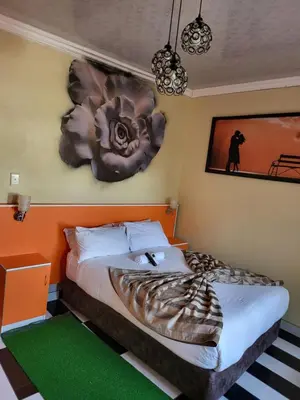 a bedroom with two beds and a flower on the wall at Blackwood Guest House in Pretoria