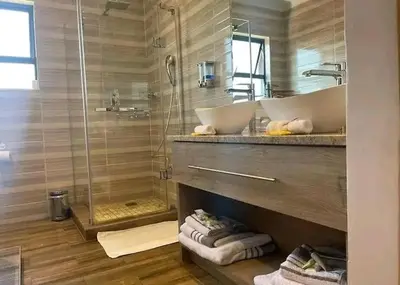 a bathroom with two sinks and a shower at Indalo in Burgersfort