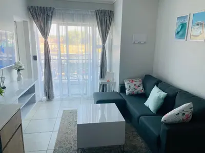 a living room with a couch and a table at Cozy Apartment at The Blyde in Pretoria