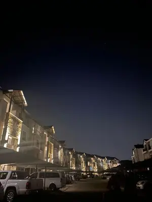 a row of buildings with cars parked in a parking lot at Cozy Apartment at The Blyde in Pretoria
