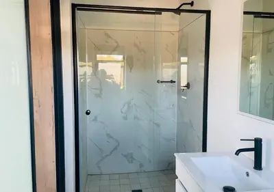 a glass shower in a bathroom with a sink at Cozy Apartment at The Blyde in Pretoria