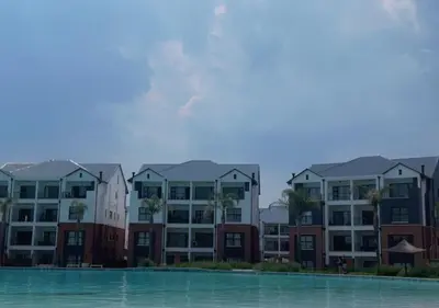 a row of apartment buildings next to a body of water at Cozy Apartment at The Blyde in Pretoria