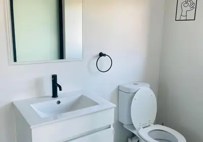 a bathroom with a sink and a toilet and a mirror at Cozy Apartment at The Blyde in Pretoria