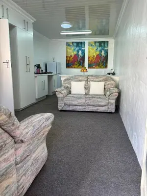 a living room with two couches in a room at Load shedding free studio apartment in Pretoria