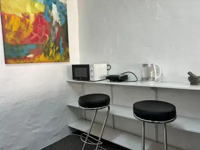 two stools sitting on a shelf with a microwave at Load shedding free studio apartment in Pretoria