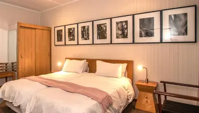 a bedroom with a bed and pictures on the wall at Graskop Hotel in Graskop