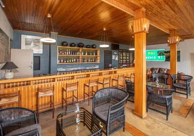 a restaurant with a bar with chairs and tables at Graskop Hotel in Graskop