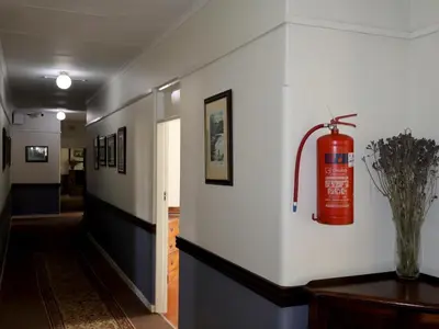 a fire extinguisher is on the wall of a hallway at The Dullstroom Inn in Dullstroom