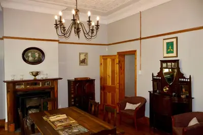 a dining room with a table and a chandelier at The Dullstroom Inn in Dullstroom