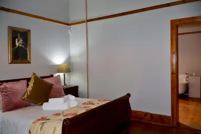 a bedroom with a bed and a mirror at The Dullstroom Inn in Dullstroom