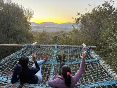 a group of three people laying on a hammock at Goldeneye Chalet -Hidden Gem of Hartees in Hartbeespoort