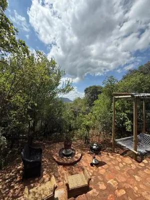 a patio with a table and a grill and trees at Goldeneye Chalet -Hidden Gem of Hartees in Hartbeespoort