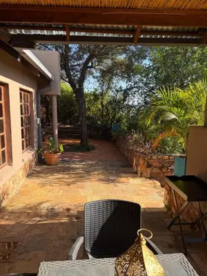 a patio of a house with a chair and a table at Goldeneye Chalet -Hidden Gem of Hartees in Hartbeespoort