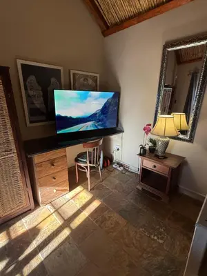 a living room with a flat screen tv on the wall at Goldeneye Chalet -Hidden Gem of Hartees in Hartbeespoort