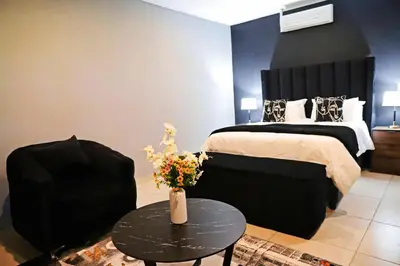 a bedroom with a bed and a table with flowers on it at Siyabonga Boutique Lodge in Nelspruit