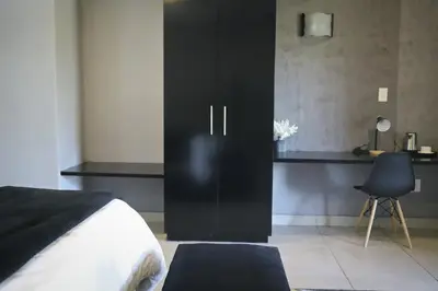 a black cabinet in a bedroom with a desk at Siyabonga Boutique Lodge in Nelspruit