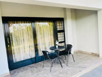 a table and chairs in front of a house at Siyabonga Boutique Lodge in Nelspruit