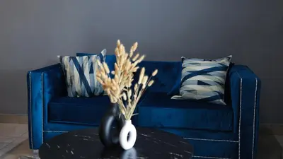 a blue couch with pillows and a vase on a table at Siyabonga Boutique Lodge in Nelspruit