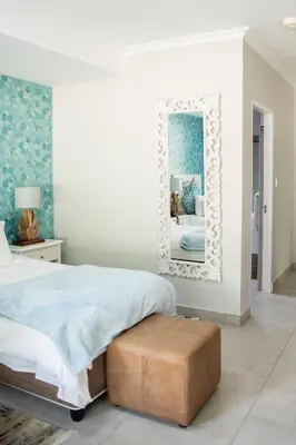 a bedroom with a bed and a mirror at The African Penguin Guesthouse in Pretoria