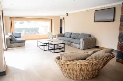 a living room with couches and a tv on the wall at The African Penguin Guesthouse in Pretoria