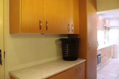 a kitchen with wooden cabinets and a counter top at Blue Orchid in Midrand