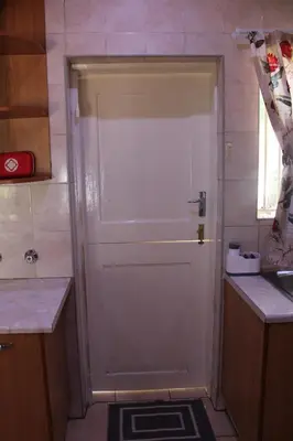 a bathroom with a shower with a white door at Blue Orchid in Midrand