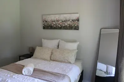 a bedroom with a bed and a painting on the wall at Blue Orchid in Midrand