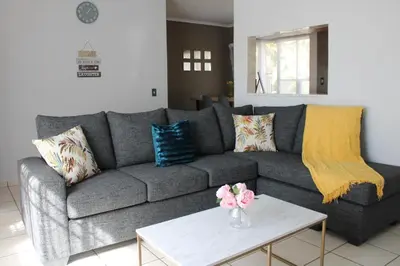 a living room with a gray couch and a table at Blue Orchid in Midrand