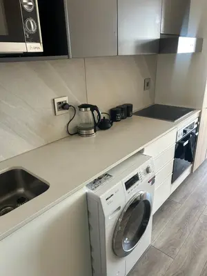 a kitchen with a washing machine and a sink at Trilogy Cozy Studio in Pretoria
