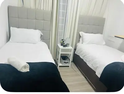 a bedroom with two beds and a night stand at 4beds,3 bedrooms,Braai,Full kitchen in Tzaneen