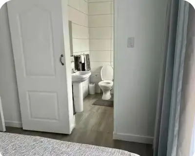 a white bathroom with a toilet and a sink at 4beds,3 bedrooms,Braai,Full kitchen in Tzaneen