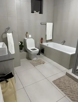 a bathroom with a tub and a toilet and a sink at 273OnNew Road in Midrand