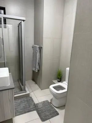 a white bathroom with a toilet and a shower at 273OnNew Road in Midrand