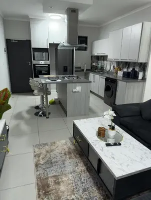 a kitchen and living room with a couch and a table at 273OnNew Road in Midrand