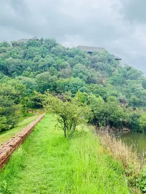 a grassy field next to a river with a mountain at Mabalingwe Mistykie Lodge in Warmbaths