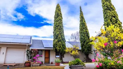 a house with a solar roof with trees at sleepwell inn in Midrand