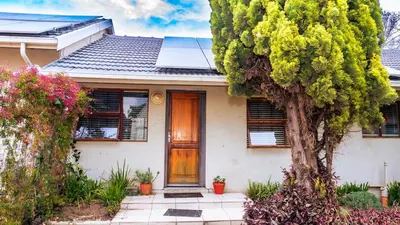 a house with a wooden door and a tree at sleepwell inn in Midrand