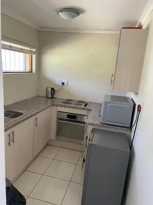 a small kitchen with a stove and a microwave at sleepwell inn in Midrand