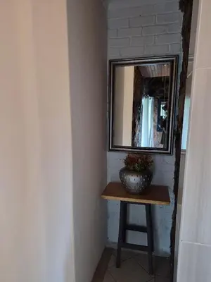 a mirror and a vase on a table in a room at Bentlys Dinokeng in Vosburg