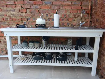a white table sitting next to a brick wall at Bentlys Dinokeng in Vosburg