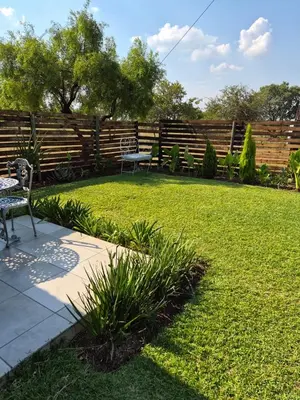 a backyard with a fence and a table and chairs at Bentlys Dinokeng in Vosburg