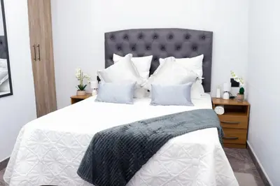 a bedroom with a large bed with white sheets and pillows at Remi's Boutique Lodge & SPA in Pretoria