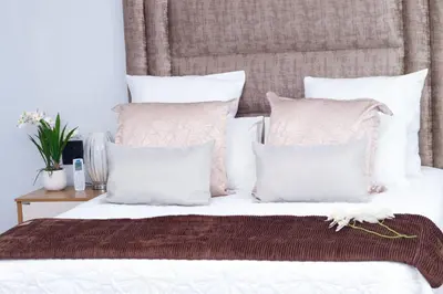 a bedroom with a bed with white pillows at Remi's Boutique Lodge & SPA in Pretoria