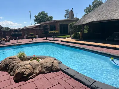 a swimming pool in a yard with a house at Remi's Boutique Lodge & SPA in Pretoria