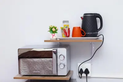 a microwave on a shelf on a wall at Remi's Boutique Lodge & SPA in Pretoria