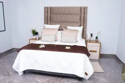 a bedroom with a large white bed with pillows at Remi's Boutique Lodge & SPA in Pretoria