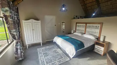 a bedroom with a large bed and a window at Die Pekanneut in Polokwane