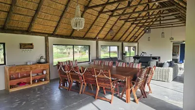 a dining room with a wooden table and chairs at Die Pekanneut in Polokwane
